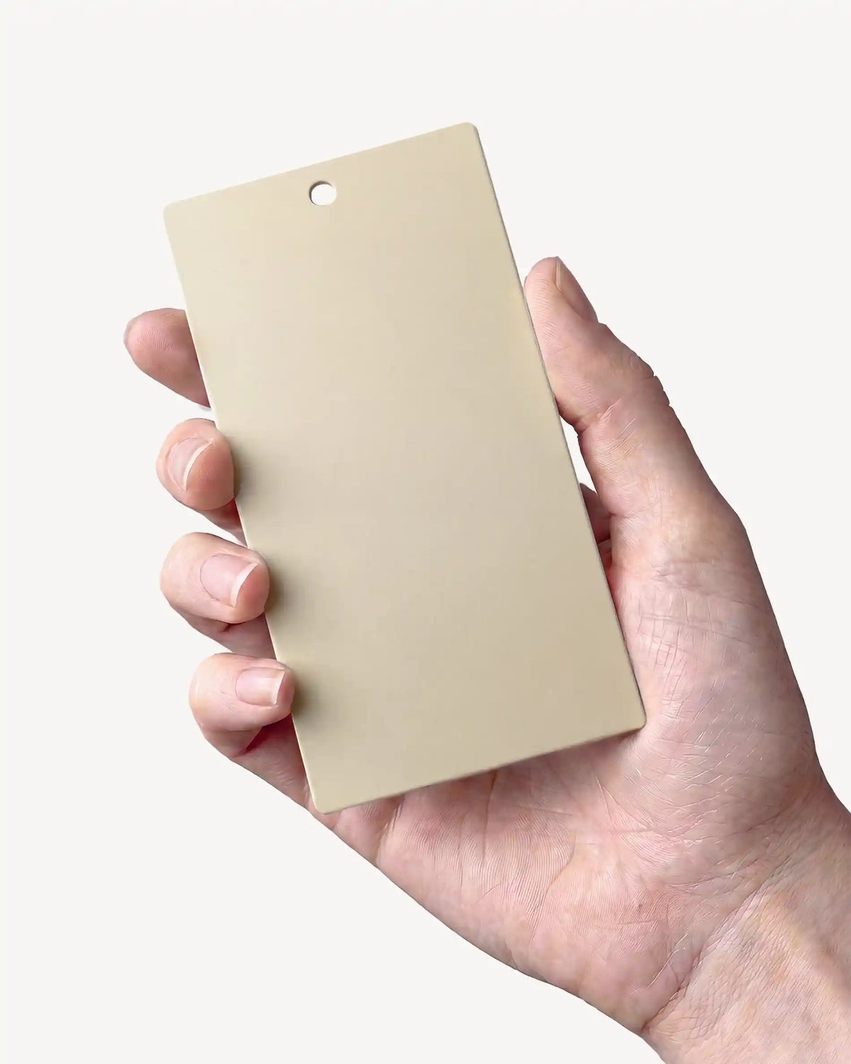 Mano che tiene un campione del colore Beige crema PILOTIS