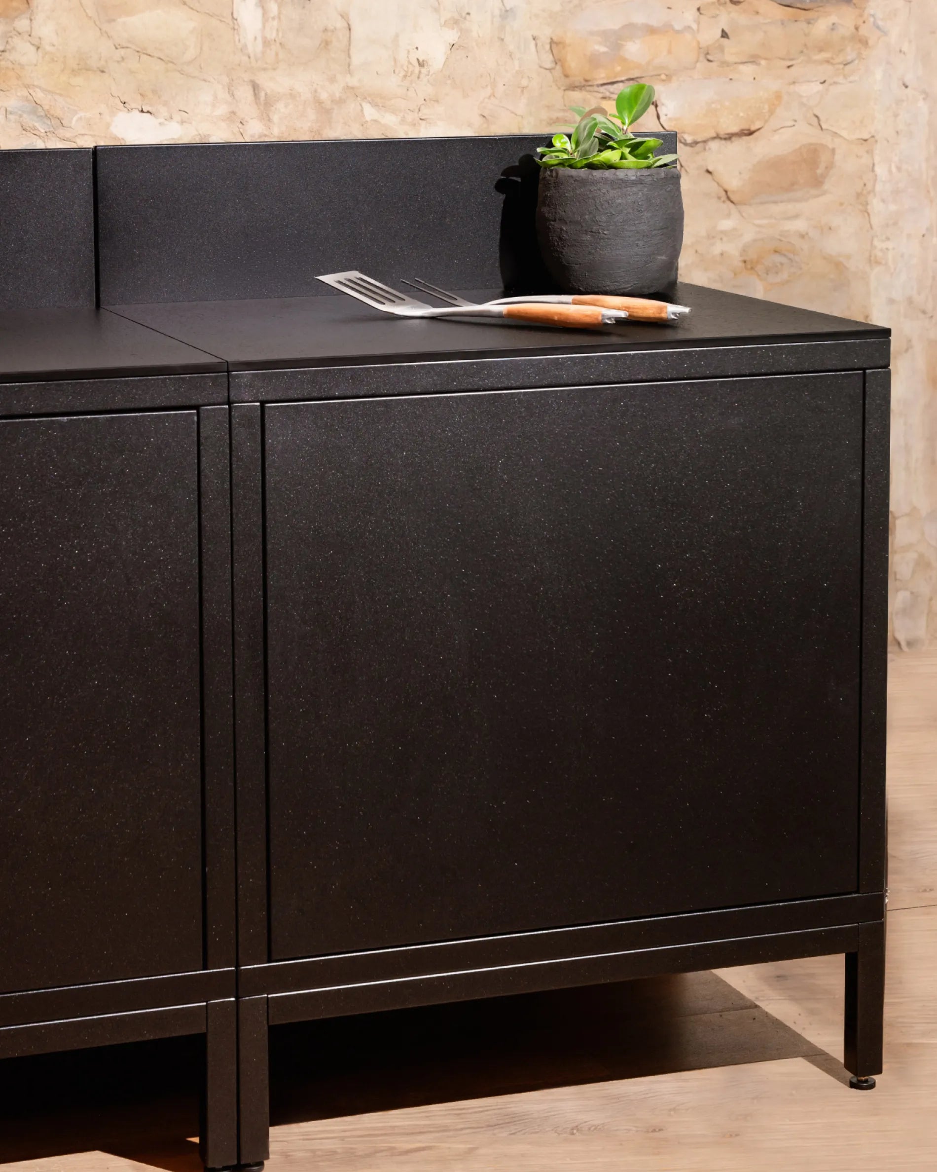 Schwarzer Korpus Modul Classic PILOTIS für die Außenküche, Arbeitsplatte mit Pflanze und Besteck