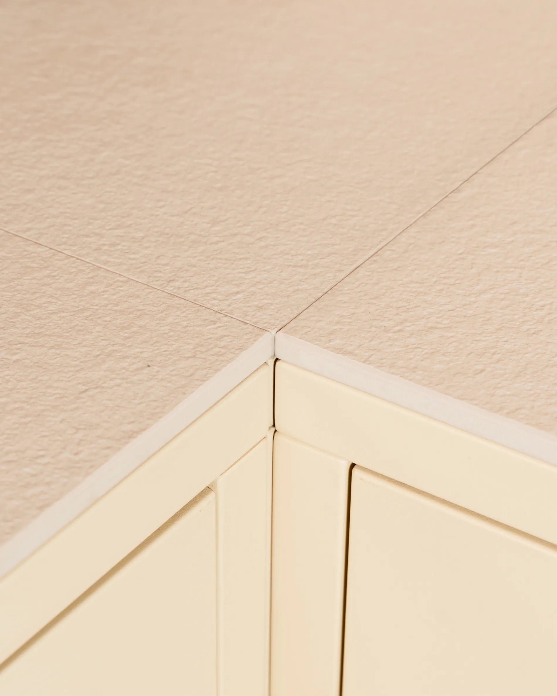 Jonction d'angle du plateau beige crème PILOTIS, gros plan sur la découpe du caisson