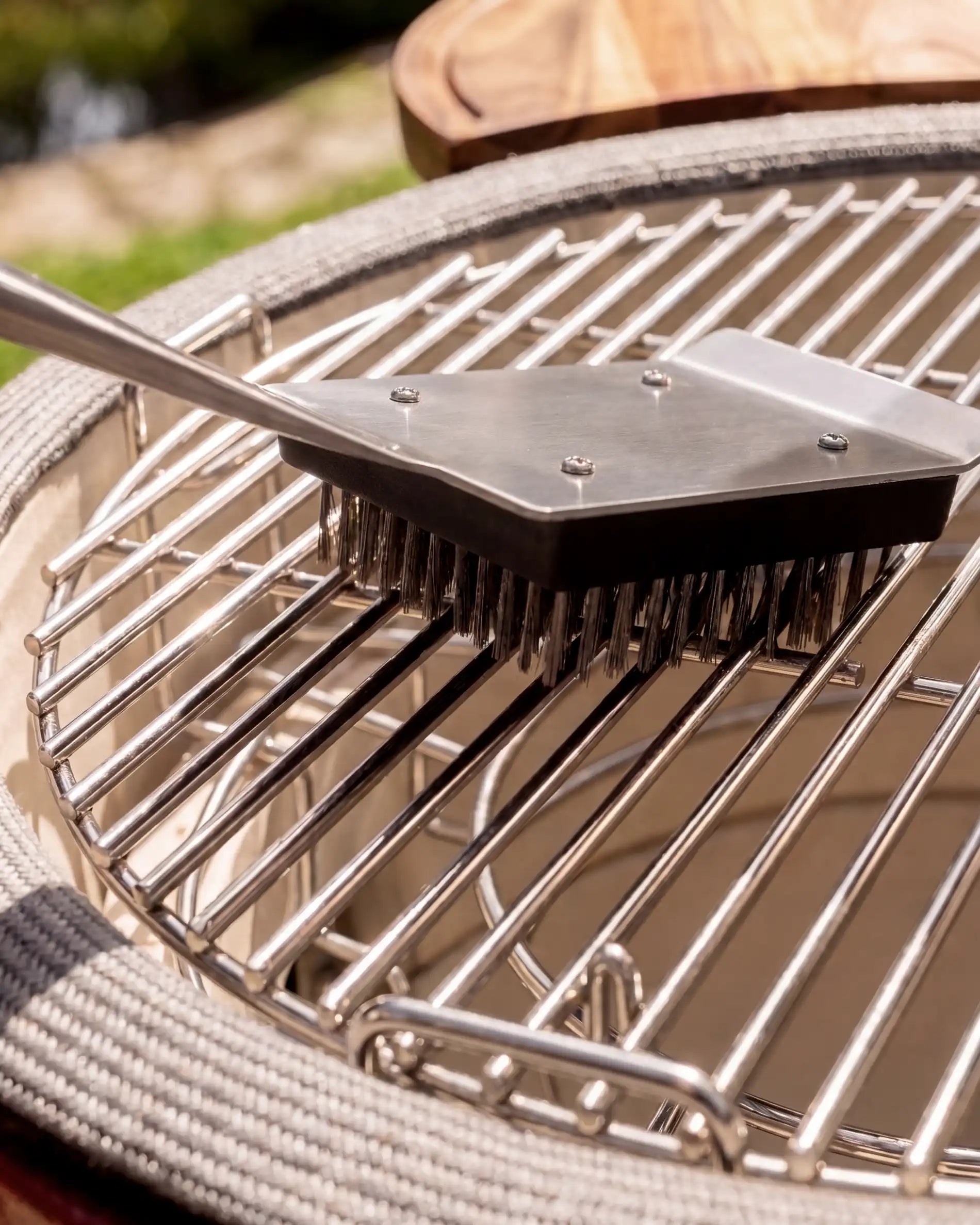 Brosse inox acacia Kokko utilisée sur une grille de barbecue