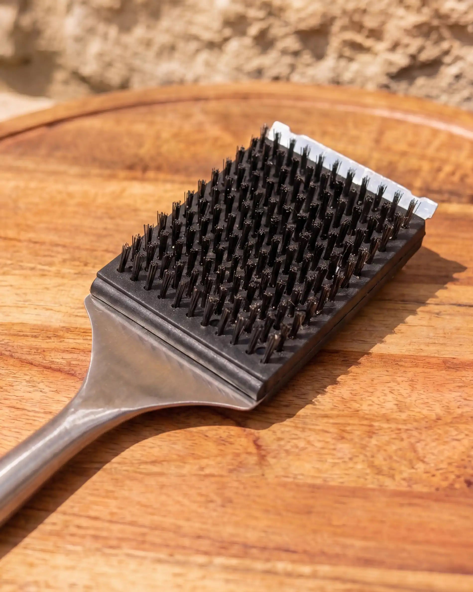 Brosse inox acacia Kokko posée sur une planche en bois