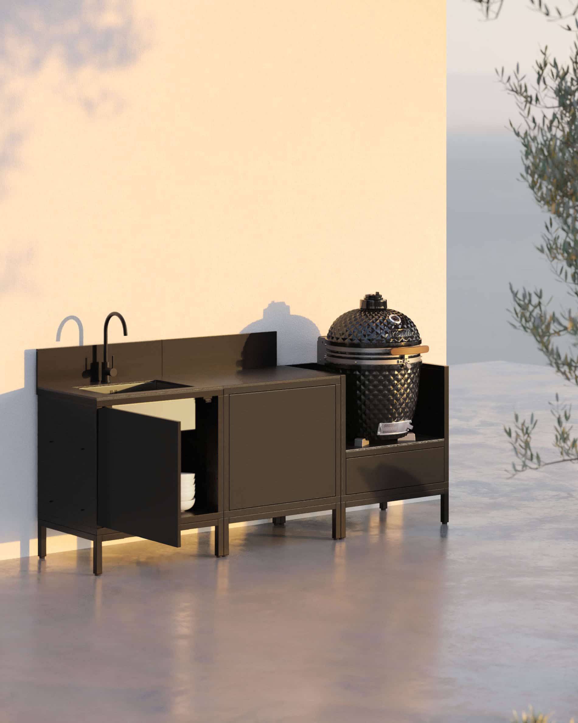 Cucina su pilotis a 3 moduli per kamado con lavello integrato, mobile nero con piano di lavoro e alzatina coordinati, lavello con rubinetto a sinistra, modulo centrale chiuso per lo stoccaggio e kamado integrato nel modulo laterale destro, struttura su piedini neri, installazione per esterni.