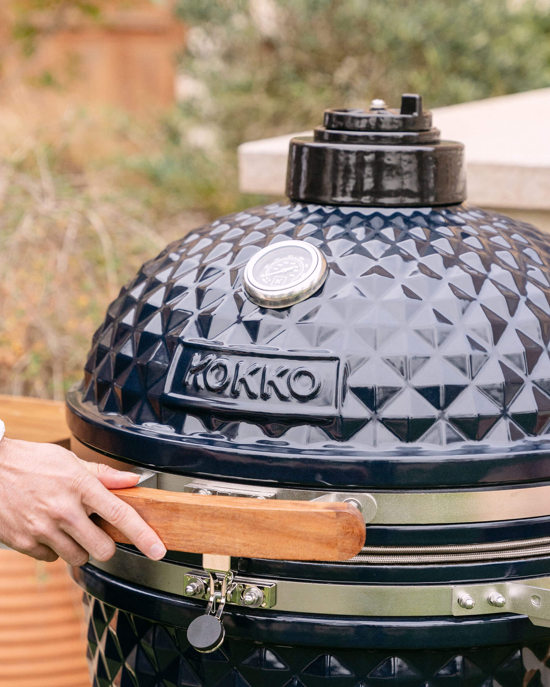 Primo piano sul coperchio di un kamado Kokko XL 22 pollici in ceramica blu navy.
