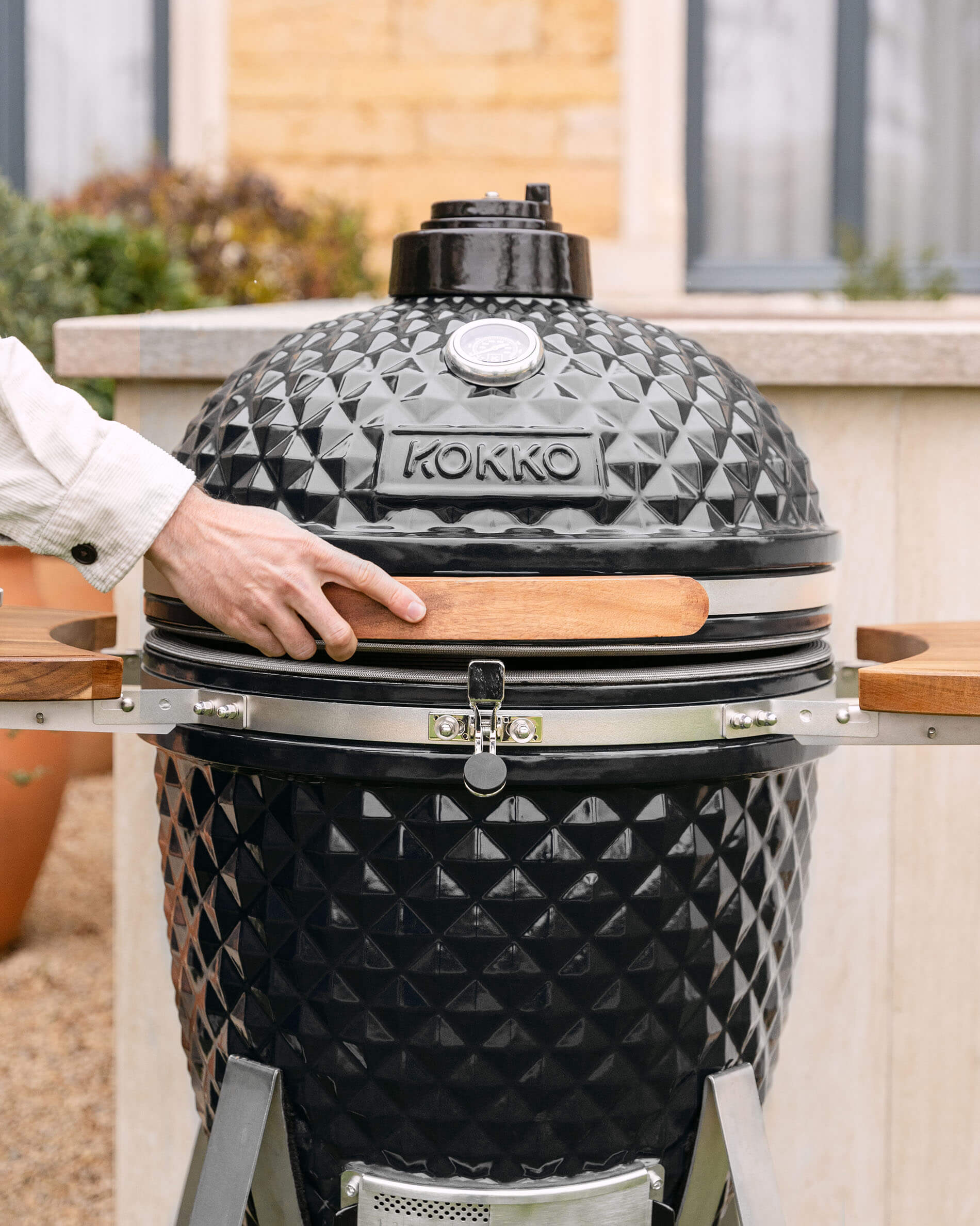 Kamado Kokko XL 22 pollici in ceramica nera installato all’esterno.
