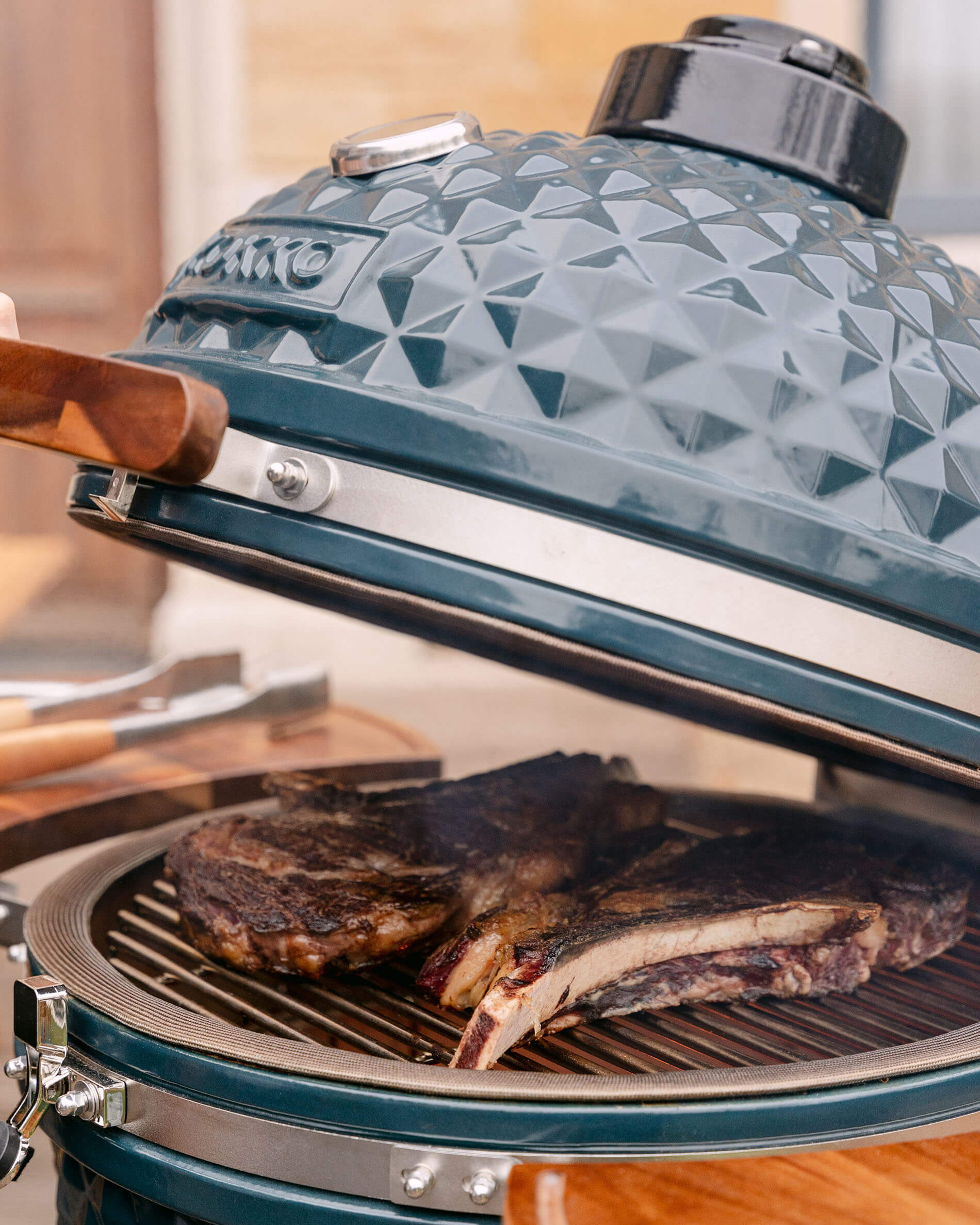 Dettaglio del coperchio di un kamado Kokko XL 22 pollici in ceramica blu oceano.