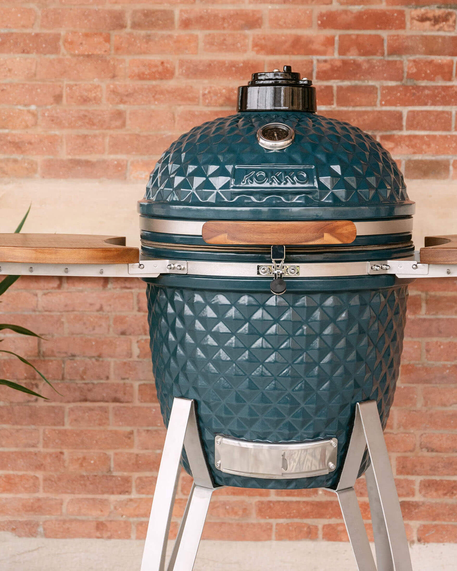 Kamado Kokko 22 pollici colore oceano, presentato da solo all’esterno.