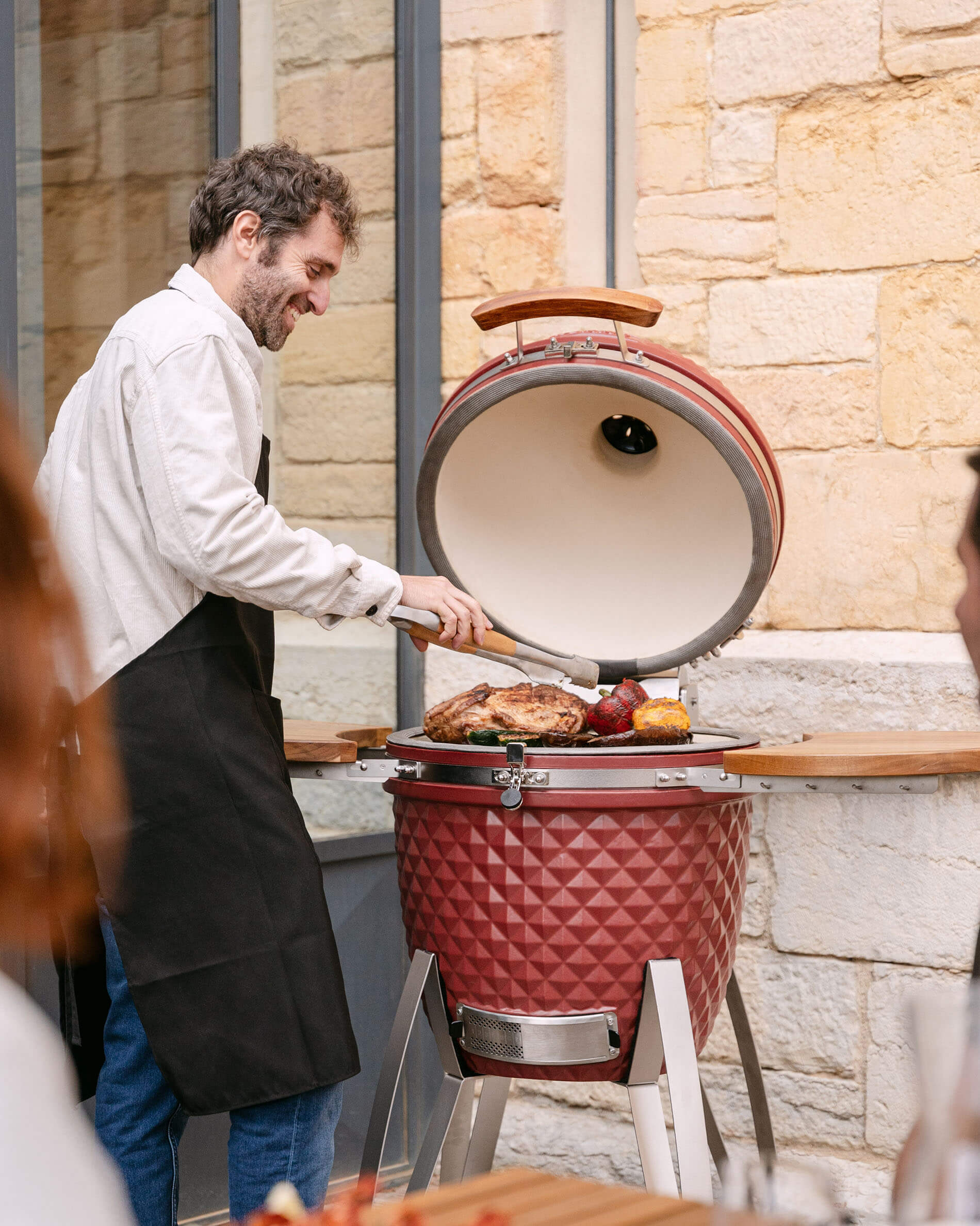 Kamado Kokko in ceramica rosso ossido da pollici utilizzato durante la cottura.