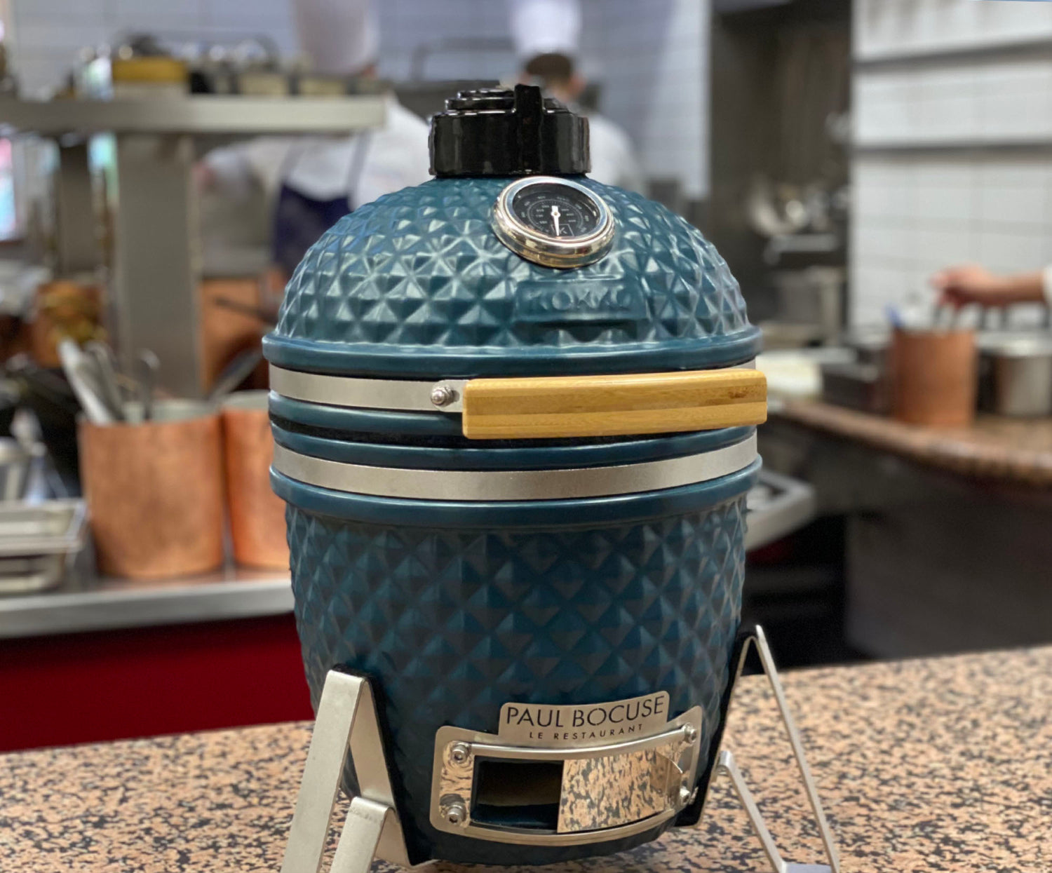 Little Kokko 13 in Ozeanblau auf einer Arbeitsfläche.