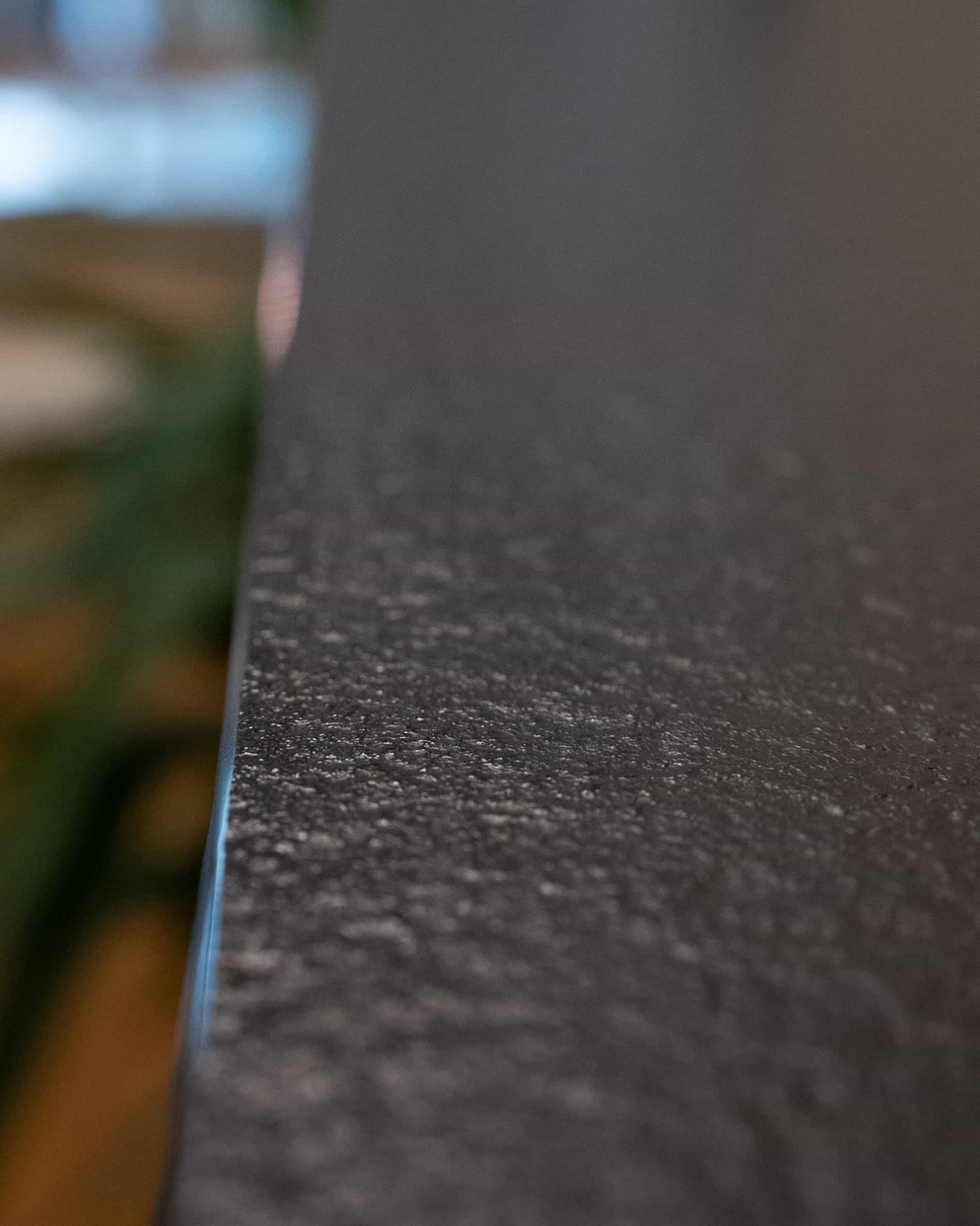 Détail du plan de travail d’une cuisine pilotis, montrant la tranche, la texture mate et la finition du matériau.