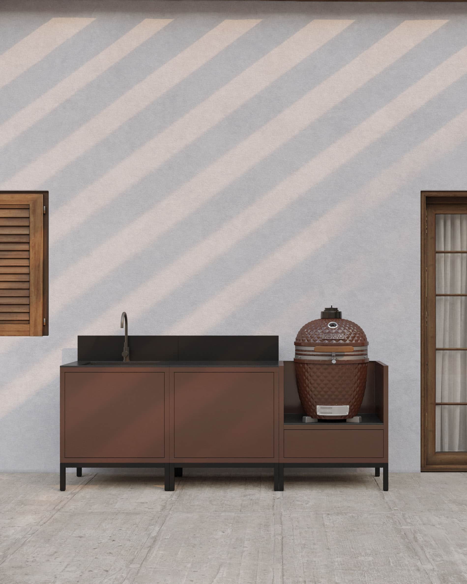 Cucina su palafitte con finitura ruggine, lavello integrato, piano di lavoro scuro, alzatina coordinata e modulo kamado dedicato su struttura rialzata.