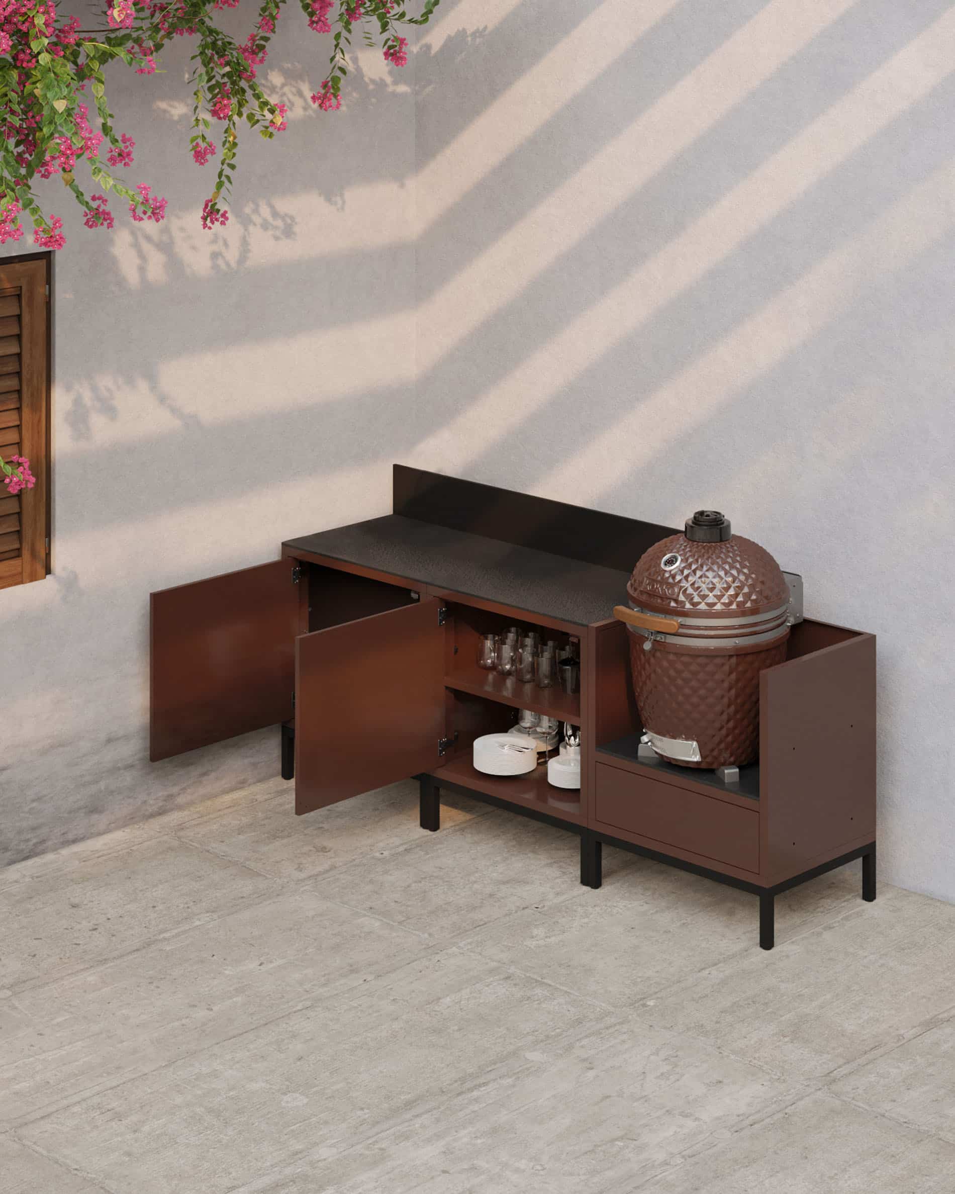 Cuisine pilotis en finition rouille avec portes ouvertes, plan de travail sombre, rangements intérieurs visibles et module kamado intégré pour une cuisine extérieure fonctionnelle.