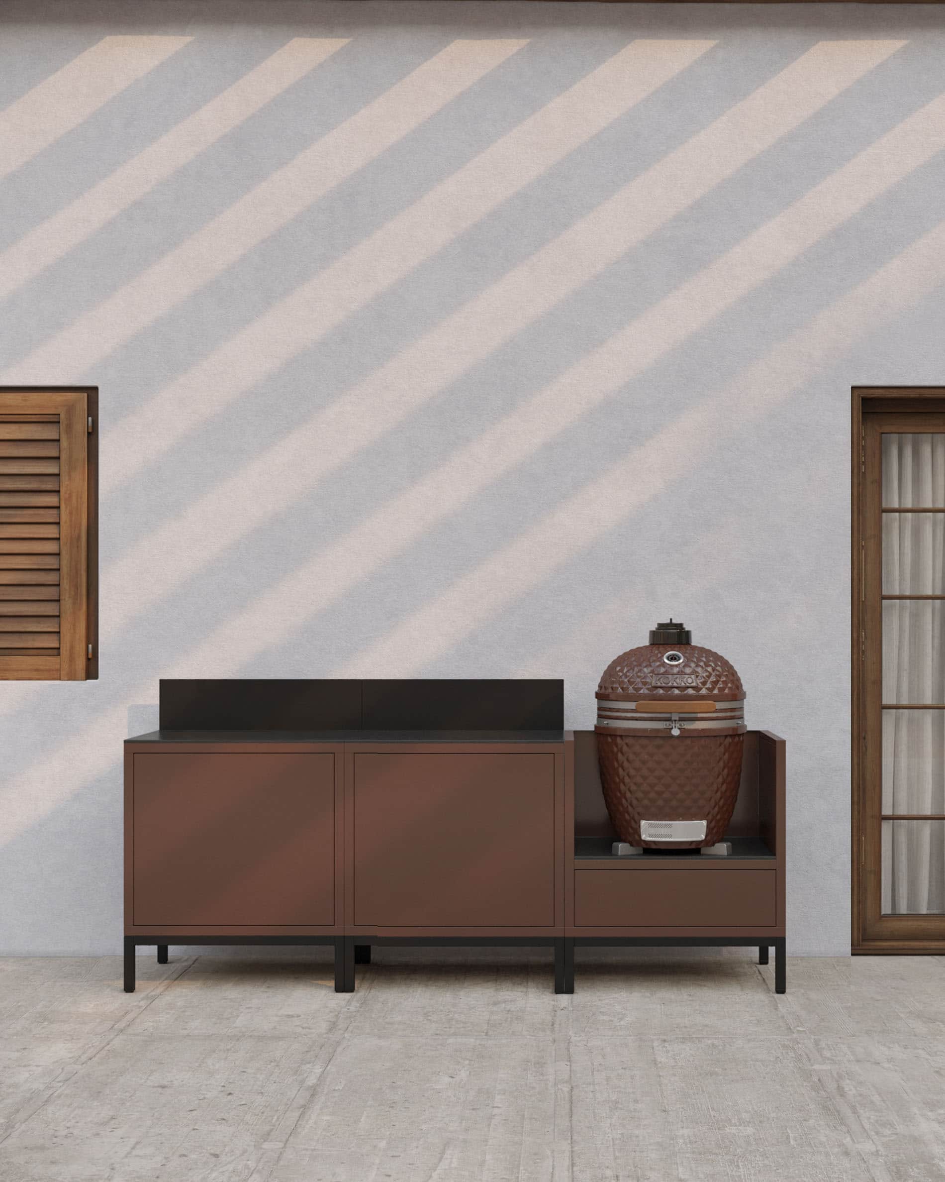 Cuisine pilotis linéaire coloris rouille avec plan de travail sombre, rangements fermés et module dédié à l’intégration d’un kamado en extérieur.