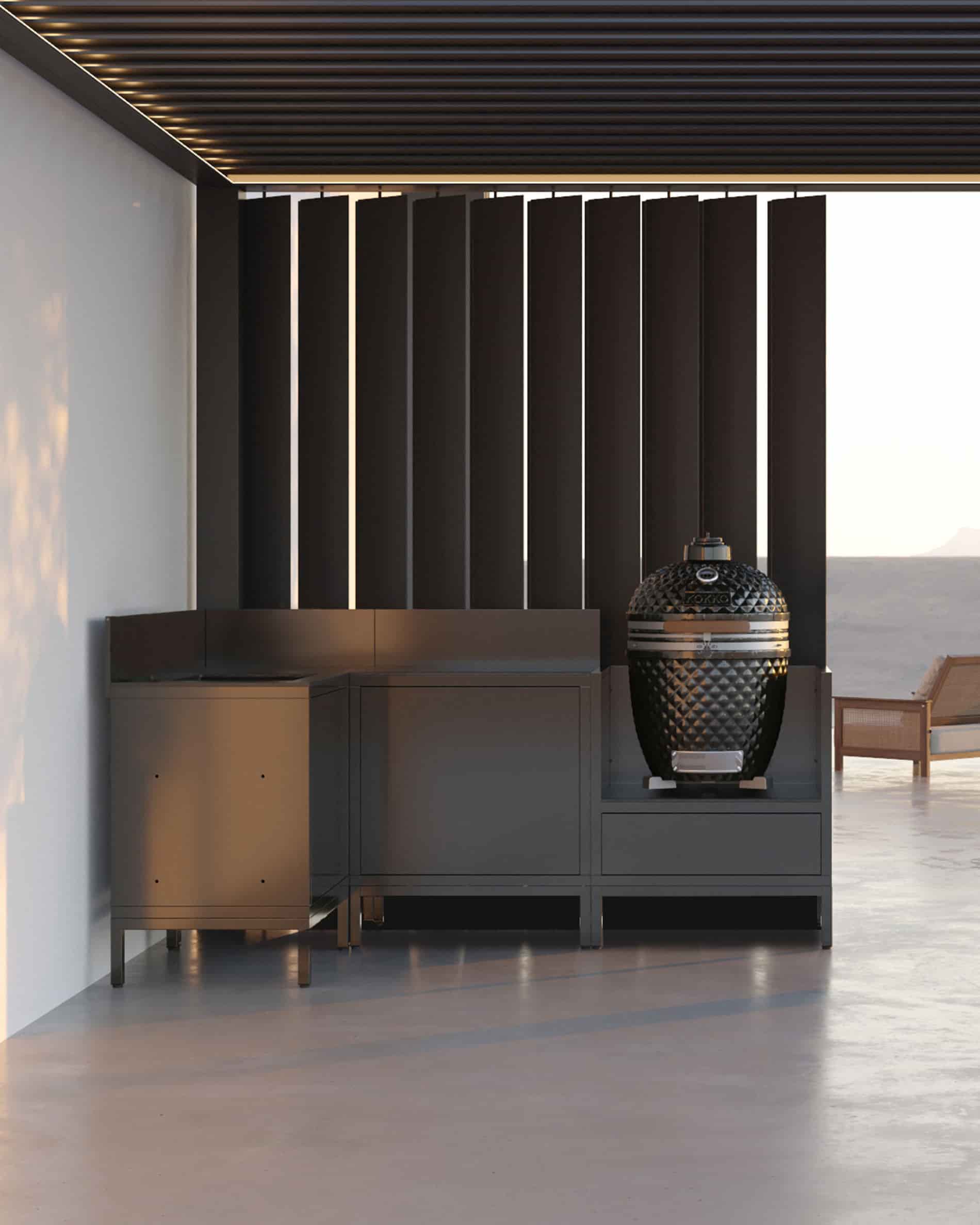 Cucina su palafitte ad angolo con kamado, mobili chiusi neri e piano di lavoro sotto pergolato.