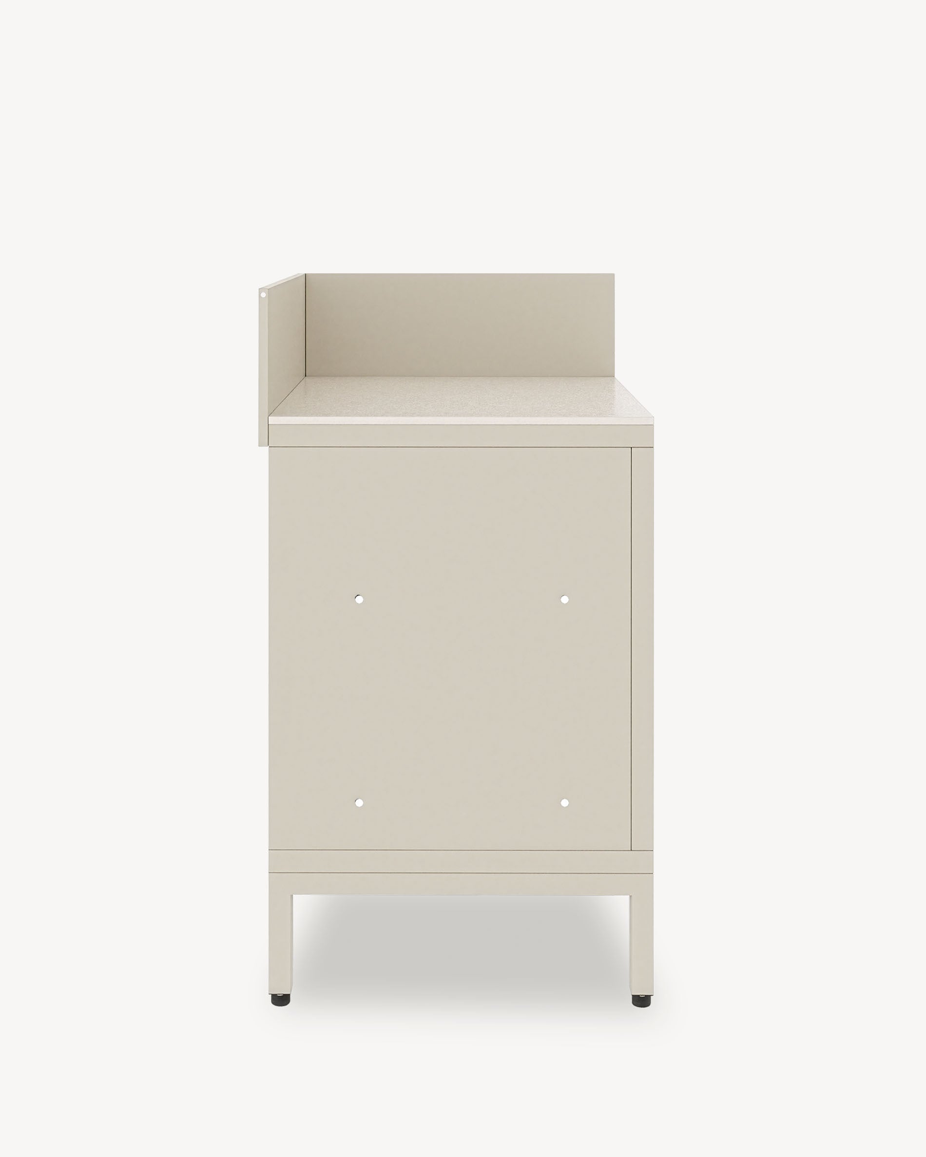 Modulo cucina angolare su pilotis, mobile color crema con vano chiuso, piano di lavoro scuro e alzatina laterale integrata.