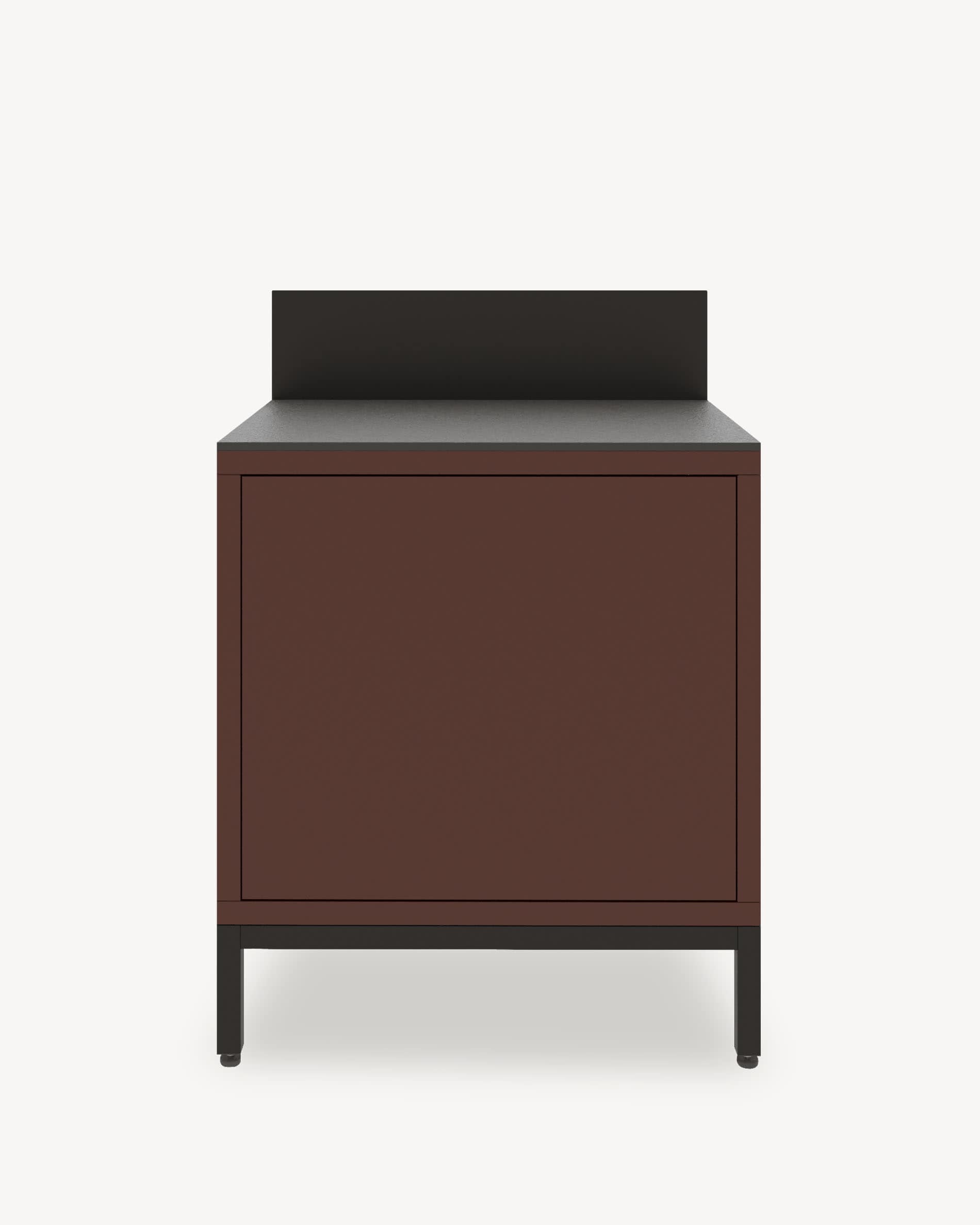 Module de cuisine pilotis classique, meuble coloris brun rouille avec rangement fermé, plan de travail sombre et crédence intégrée.