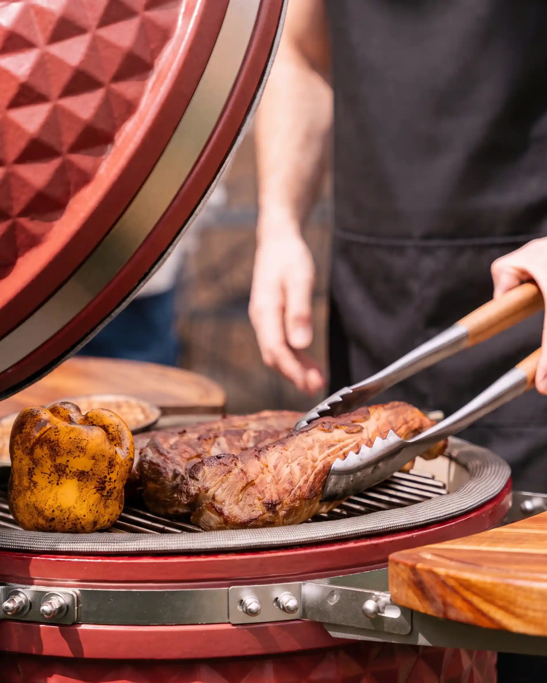 Pince inox acacia Kokko utilisée sur un kamado