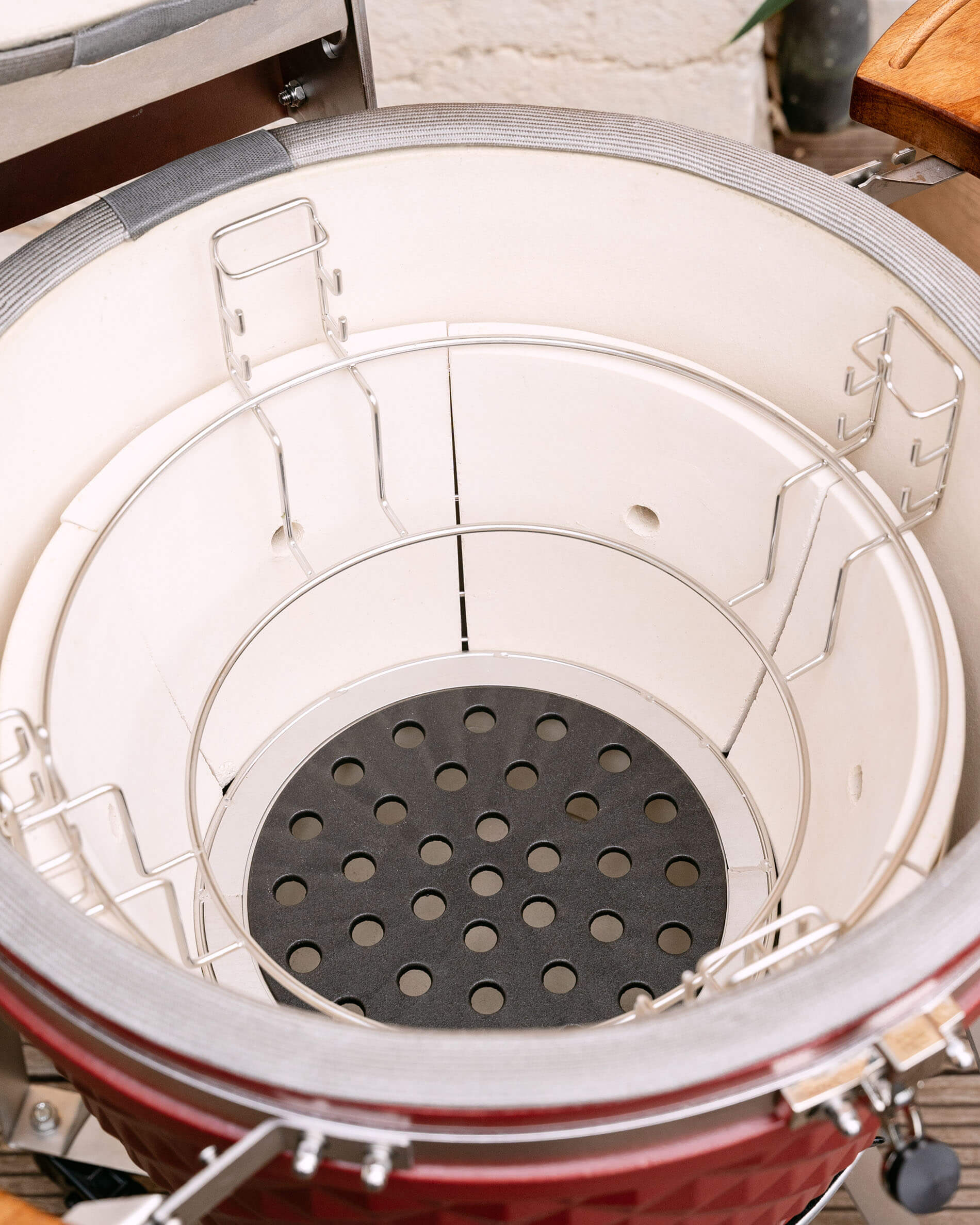 Plaque en fonte perforée pour la circulation de l’air et du charbon dans le kamado.