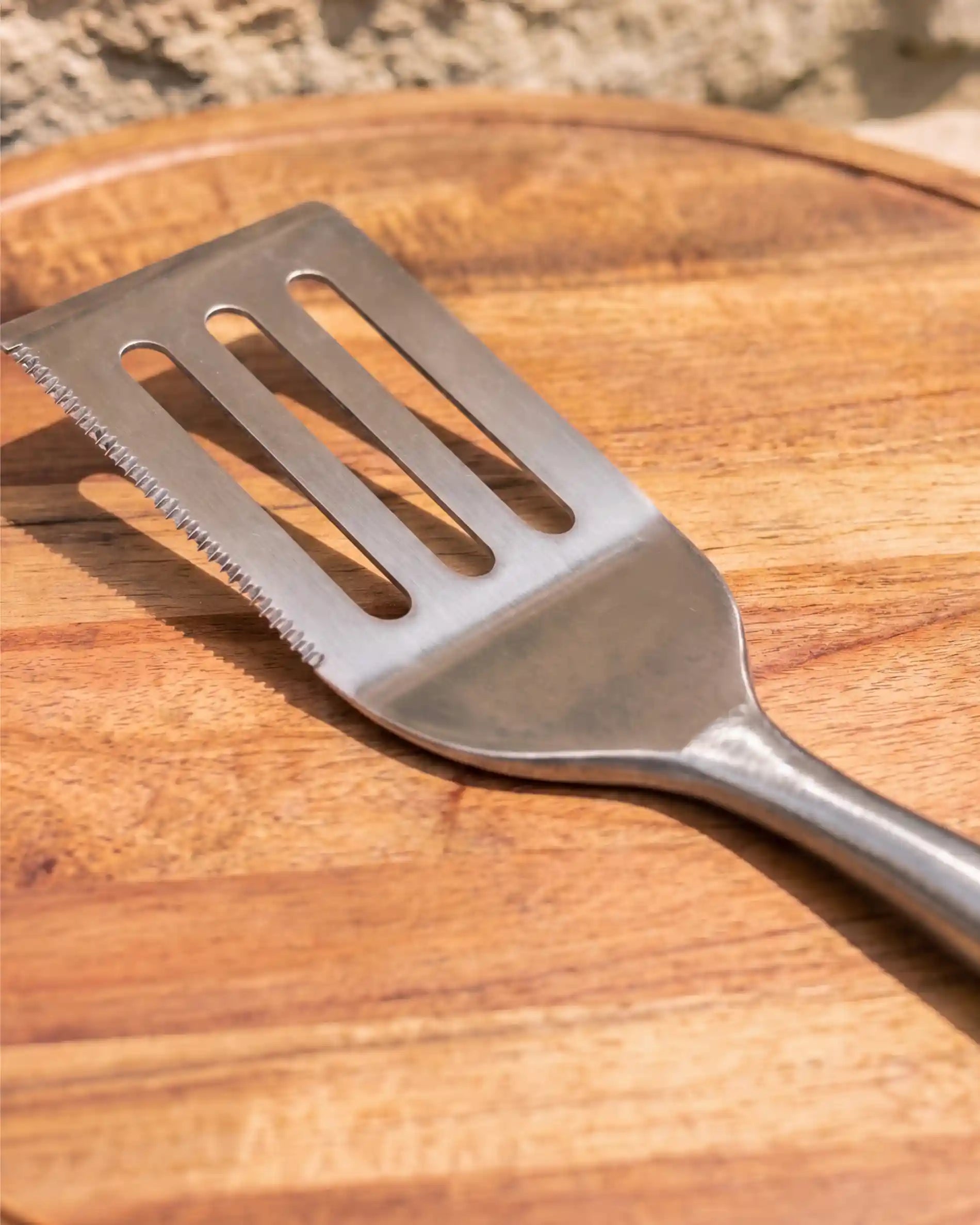 Spatule inox acacia Kokko posée sur une planche en bois